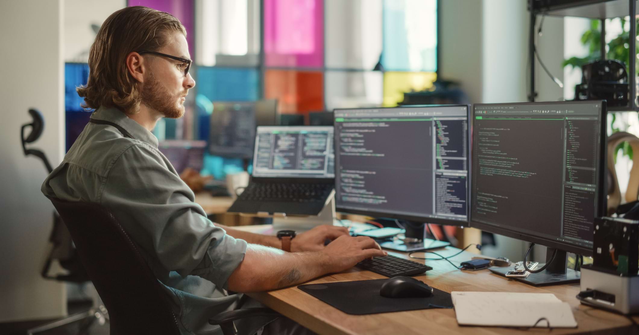 Focused student coding Python on dual monitors during Pitman Training IT Specialist course