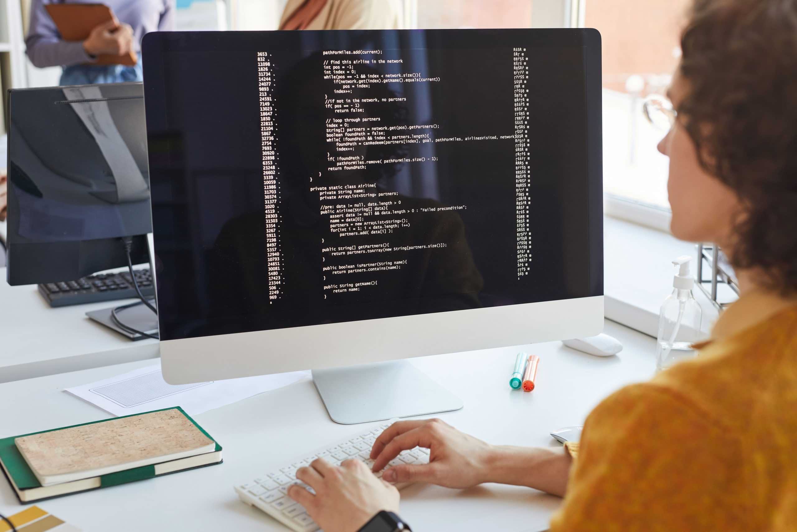 Student typing code on a desktop computer during Software Development Diploma training